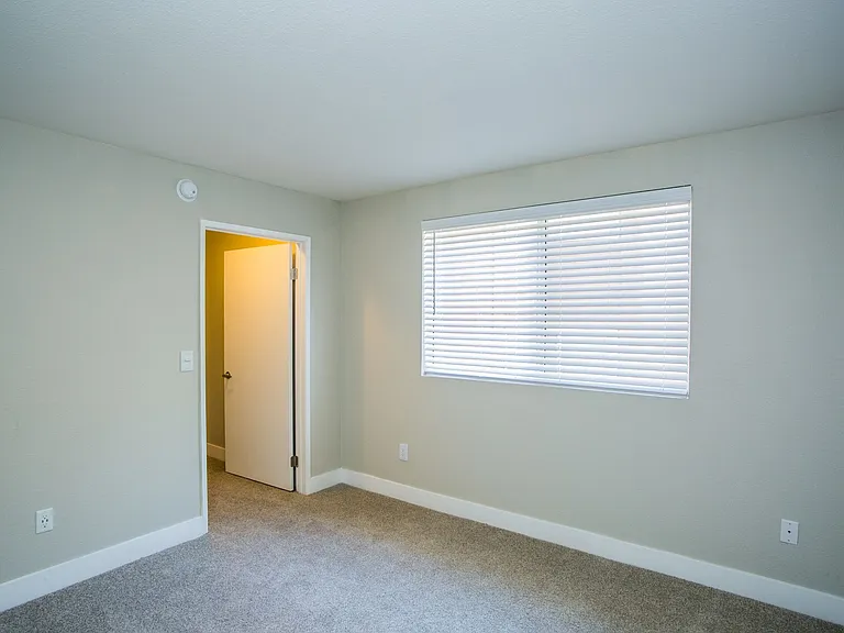 Bedroom with large baseboards, two-tone paint, tons of natural light, and door to closet.