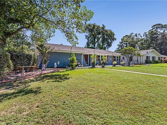Living area with crown molding, wood finished floors, a ceiling fan, and wallpapered walls
