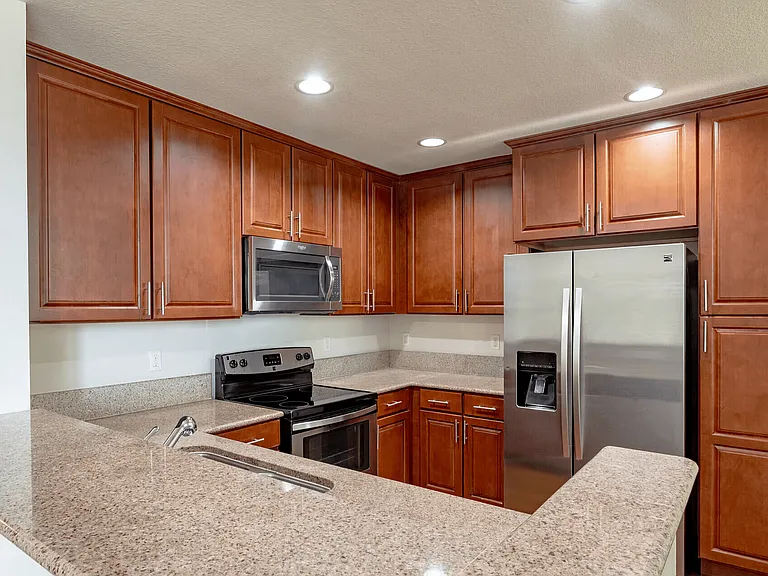 Modern kitchen with granite finishes and sleek stainless steel appliances.