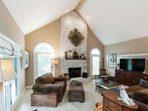Vaulted ceiling, fireplace and doors to the patio