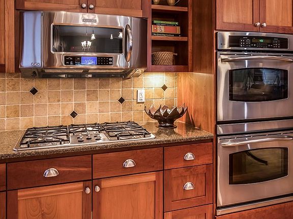 Stainless steel appliances, including a 5 burner gas cooktop and convection wall ovens make this kitchen easy to cook in.