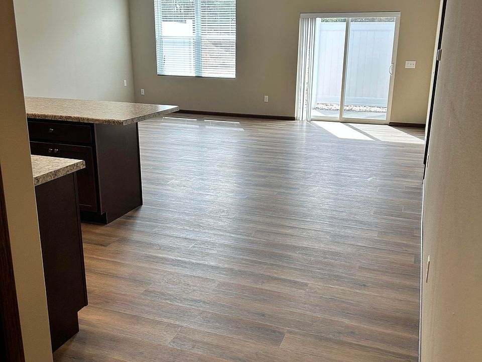 Kitchen/Living area view from entryway. Sliding glass door allows access to cement porch with privacy fence.