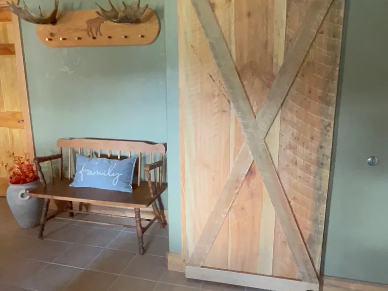 Custom made sliding barn door hides stackable washer/dryer