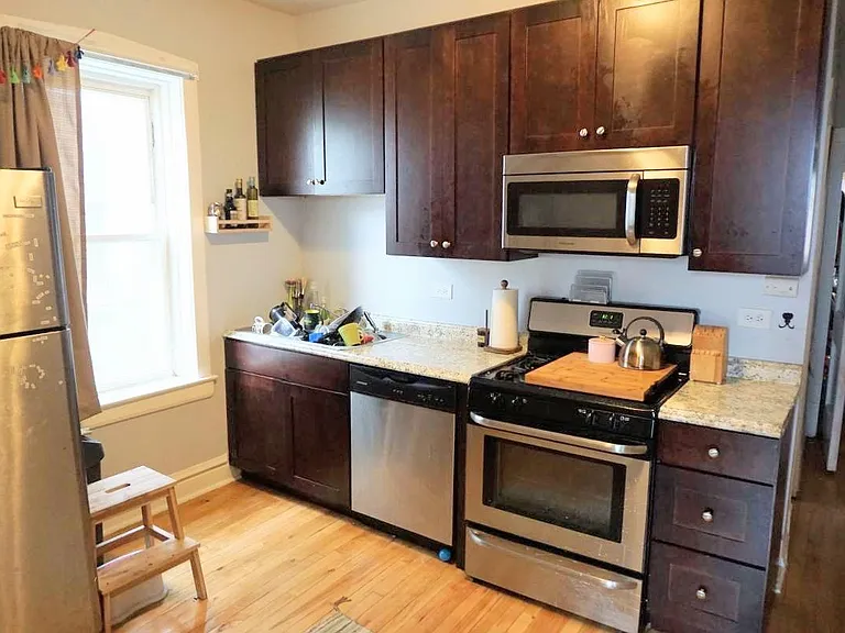Eat in kitchen with stacked laundry machines.