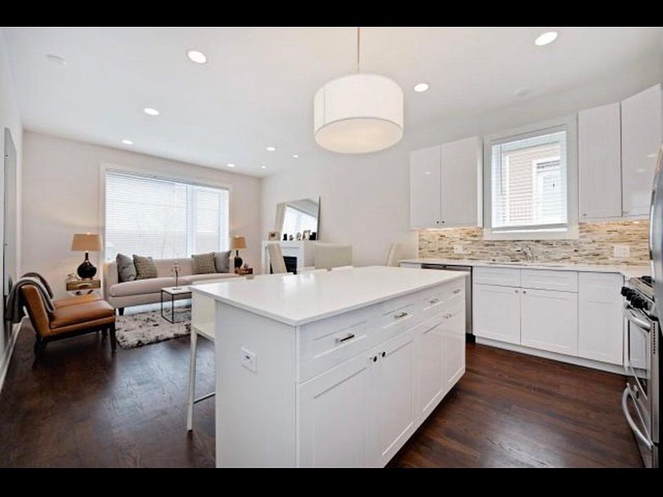 Open concept kitchen with glossy white cabinetry