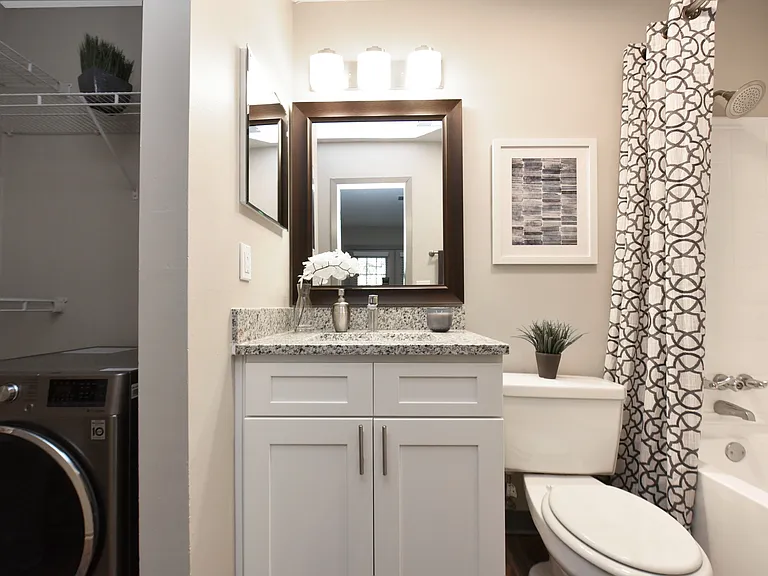 Bright bathroom with granite counters and bathtub