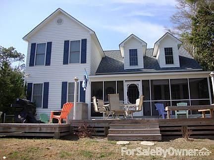 Front of House : Faces canalfront. Screened-in porch overlooks multi-level deck & custom fencing.