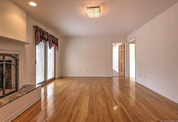 Large family room/living room with pretty raised hearth fireplace and slider leading to new deck!