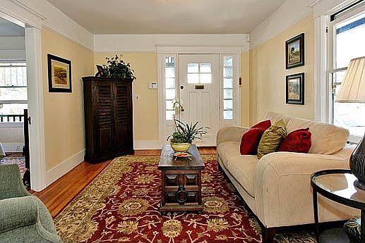 Light and lovely living room with wainscoting and gleaming fir floors