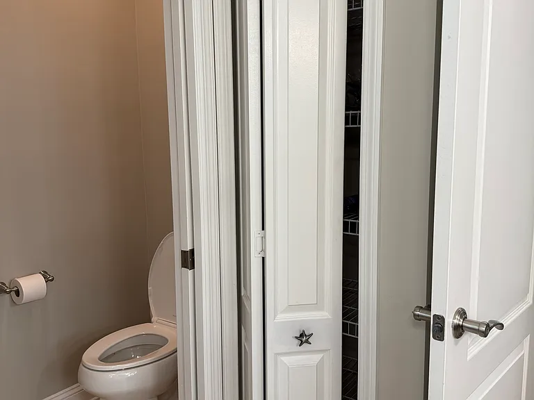 Commode with pocket door adjacent to linen closet