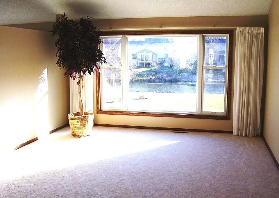Bright living room w/vaulted ceilings and pond views