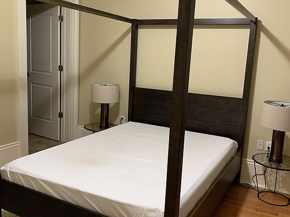 High ceilings fit this canopy bed and ceiling fan in this one Bedroom En-Suite with walk in shower
