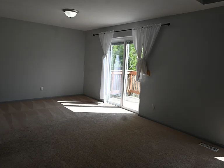 The living room/dinning room combo room with a large sliding glass door that leads to the back concrete pad.