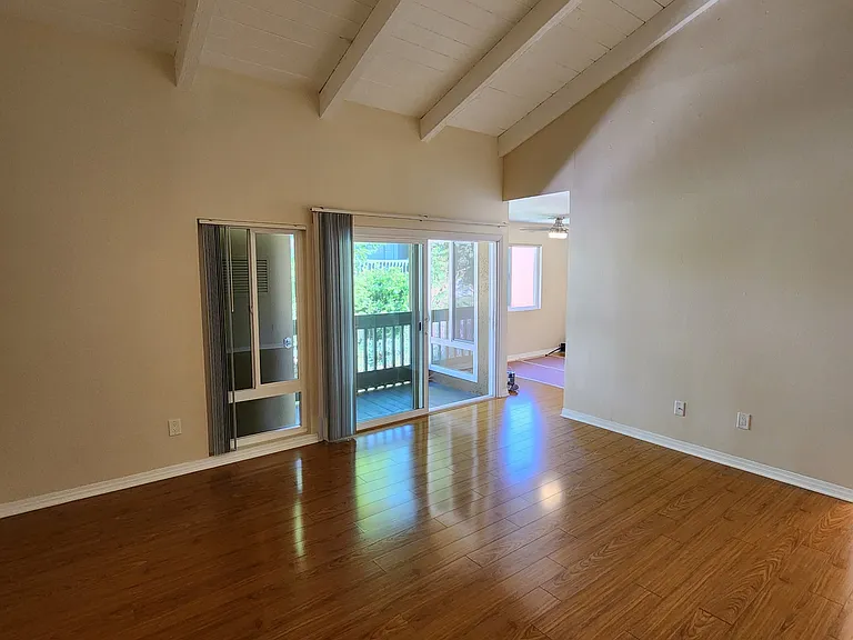 Spacious family room with vaulted ceiling and sliding door to the balcony