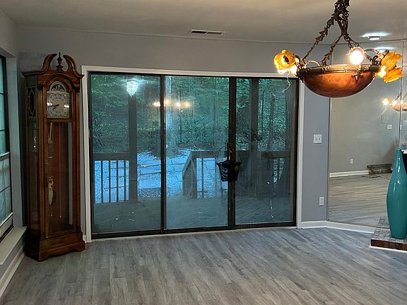 Large family room with fireplace facing to a manicure yard with burn fire pit.