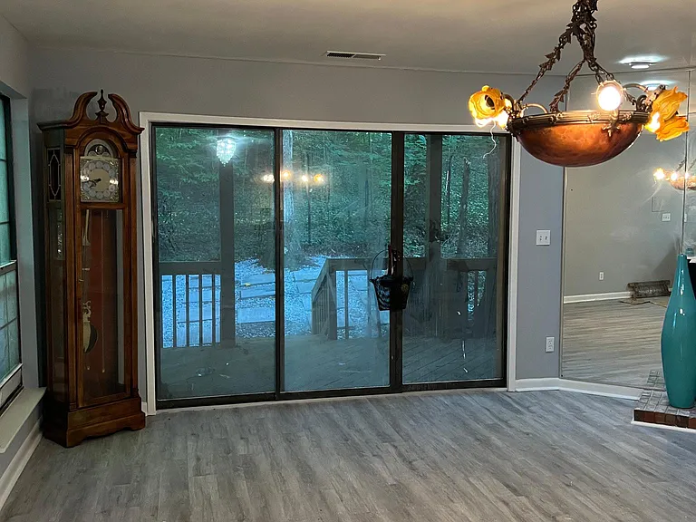 Large family room with fireplace facing to a manicure yard with burn fire pit.