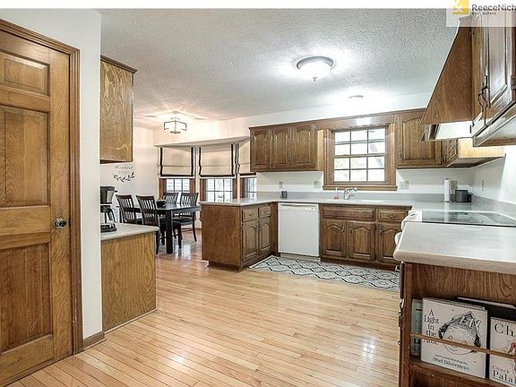 SPACIOUS KITCHEN HAS HARDWOOD FLOORS, SOLID SURFACE COUNTER TOPS.