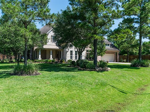 Home sits surrounded by towering trees quietly at the end of a cul-de-sac with no neighbors on one side.
