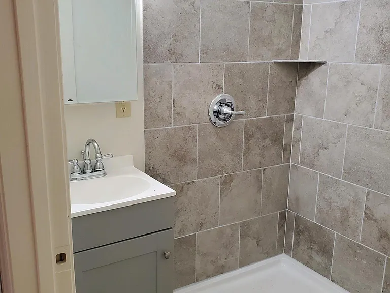 Room B - Bathroom (toilet not seen, across from mirror/sink behind the door