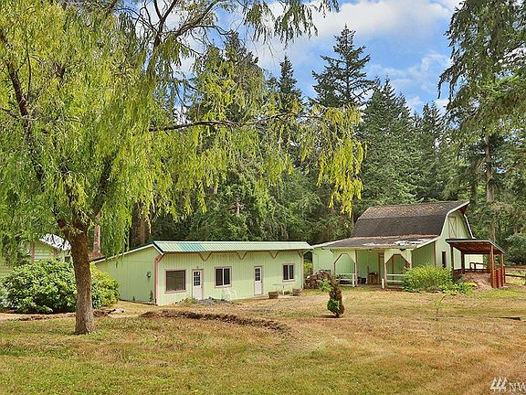 Barn with hayloft and stalls.  The one story outbuilding has one finished room and storage/shop space.  The small outbuilding to the left is the well house.  There is a shared well serving this property and a 3 bedroom septic system.