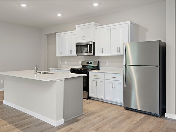 The kitchen has stainless steel appliances and white cabinets.