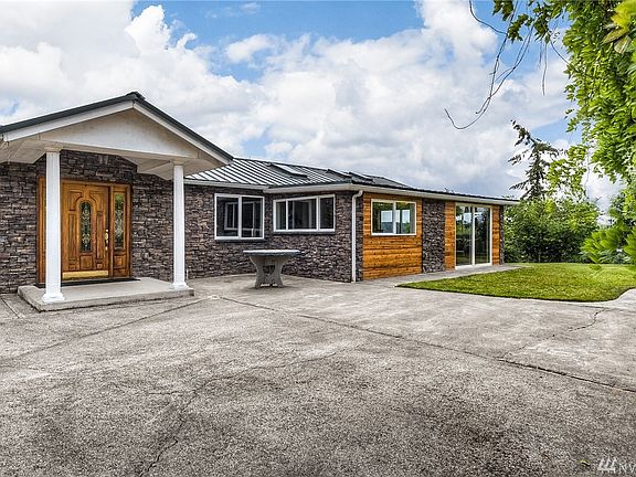 The covered front door entry, notice all the beautiful stone work and cedar siding. The slider goes to the family room. 