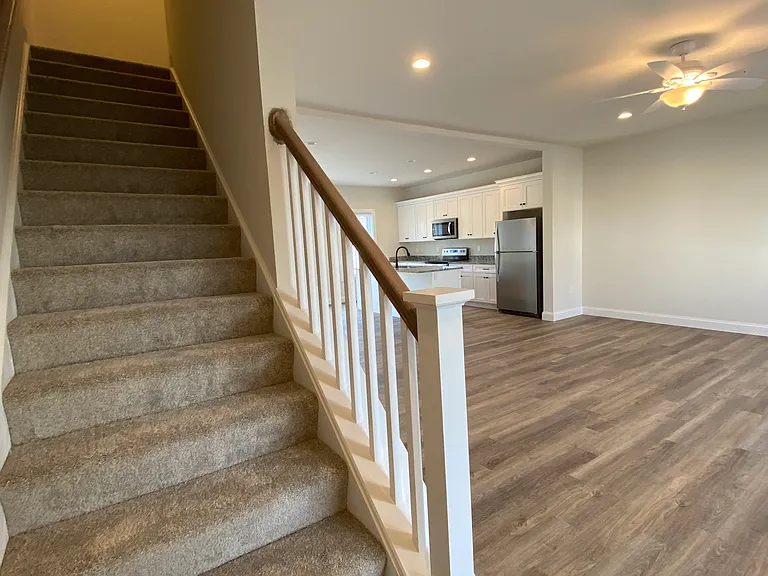 Stairwell to two guest bedrooms, primary bedroom with ensuite and walk in closet, laundry hookups and full guest bathroom