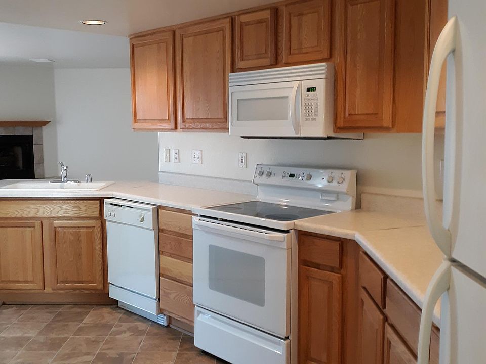 Plenty of cabinets, countertops, tile floor in kitchen.