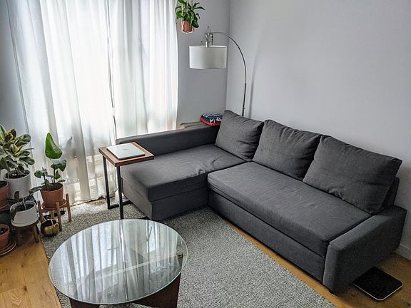 South-facing floor-to-ceiling windows letting in plenty of natural light throughout the day. Optional furnishing: Sofa with storage under chaise