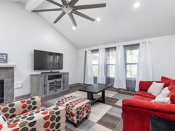 The cozy Living Room has a vaulted ceiling and tiled fireplace