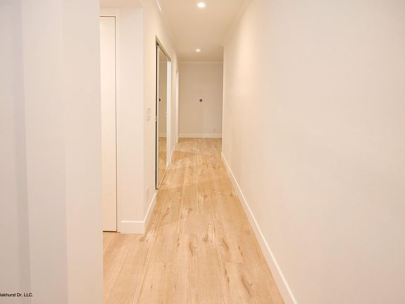 Hallway from entry to living area with two large closets and in-unit laundry to the left
