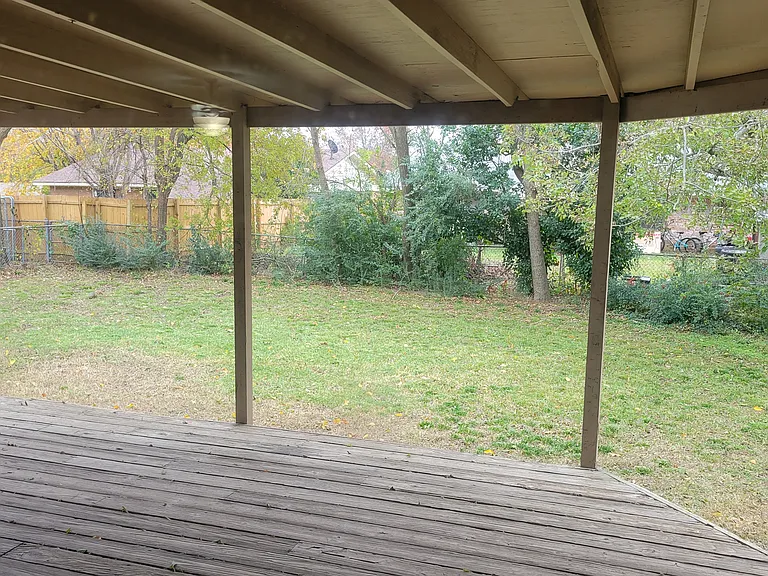 Covered deck out back door looking toward fenced back yard