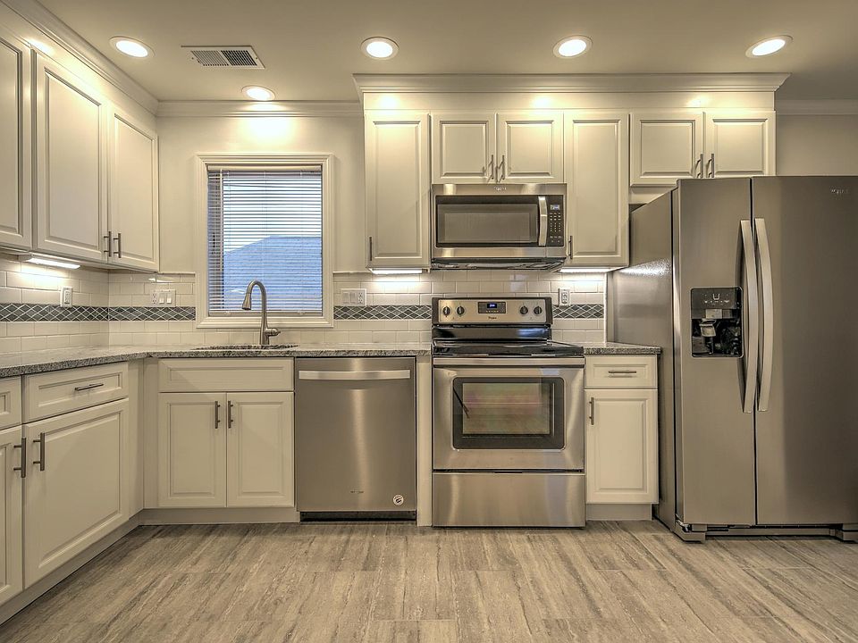 White Kitchen with granite counter top ,subway back splash and stainless steel appliances