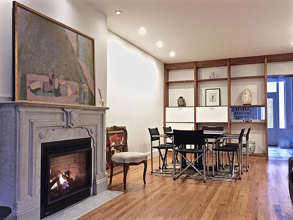 Fireplaced Living Room looking into Dining Room and Kitchen with deck beyond.