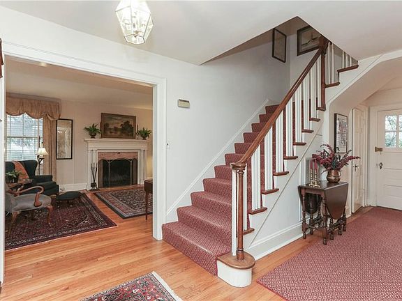 Grand staircase with curved "rat tailed " bannister painted white balusters.