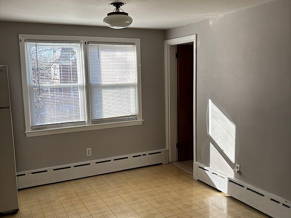 The view of the dining room area when entering from the front door, that doorway leads to the bathroom