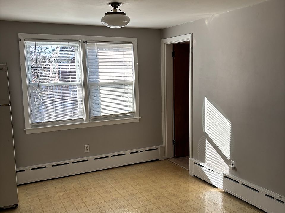 The view of the dining room area when entering from the front door, that doorway leads to the bathroom