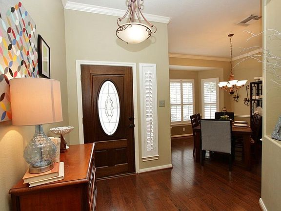 The interior offers a neutral color palette with gleaming hardwood floors and Plantation shutters.