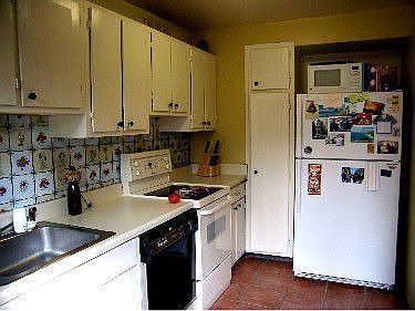 Sunny galley kitchen with  white appliances