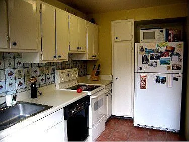 Sunny galley kitchen with  white appliances