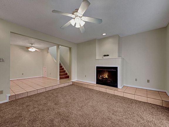 A Living Room With a Ceiling Fan and Fireplace