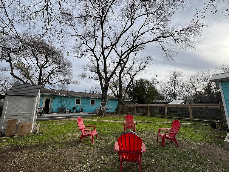 Backyard with shed, firepit, and exterior fence