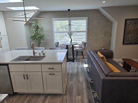 Island/Dining/Living. 3 seats at island, 2 at counter height table at window.

Island contains large sink, disposer, instant hot water, dishwasher, double trash bin. Storage on other side.