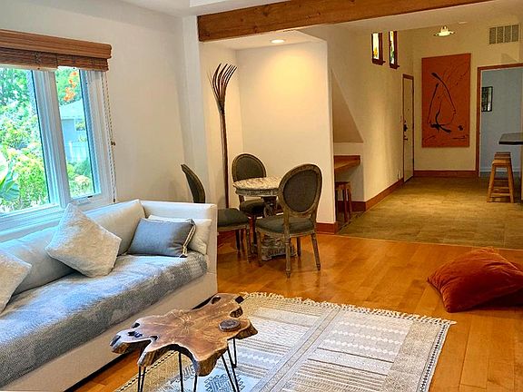 View of Living room, desk nook, entry hall, and beam ceilings.