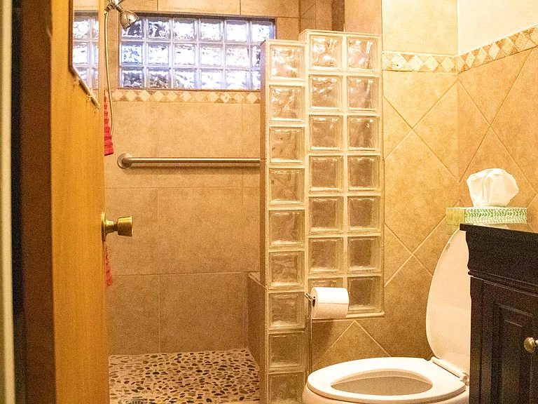 Newly remodeled bathroom off of bedrooms #2 and #3. Shower with built in tile bench and two grab bars.