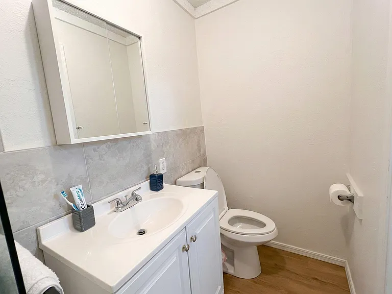 Updated bath with a single-sink vanity, mirrored medicine cabinet, and tile backsplash for easy everyday use.