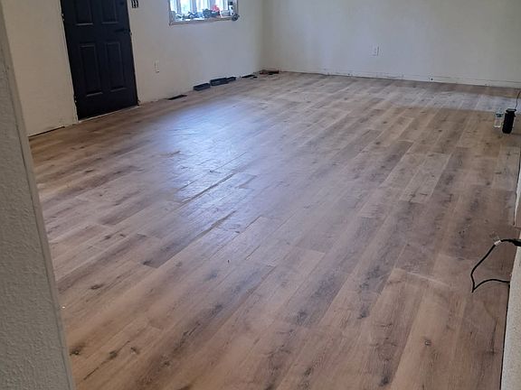 Large open living space with new flooring, new ceiling fans with remotes