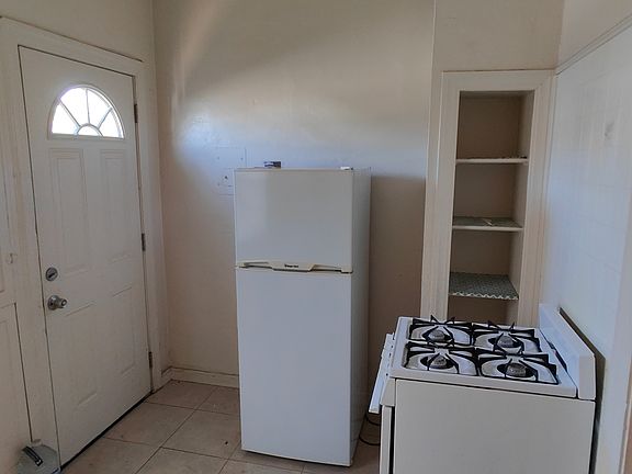 There are easy-care tile floors in the kitchen. The appliances are apartment-sized. The back door leads to a small yard.