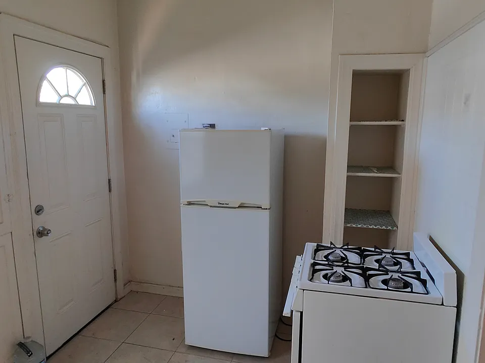 There are easy-care tile floors in the kitchen. The appliances are apartment-sized. The back door leads to a small yard.