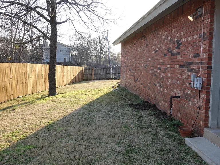 Stepping off the covered back patio and looking right into the back yard area.